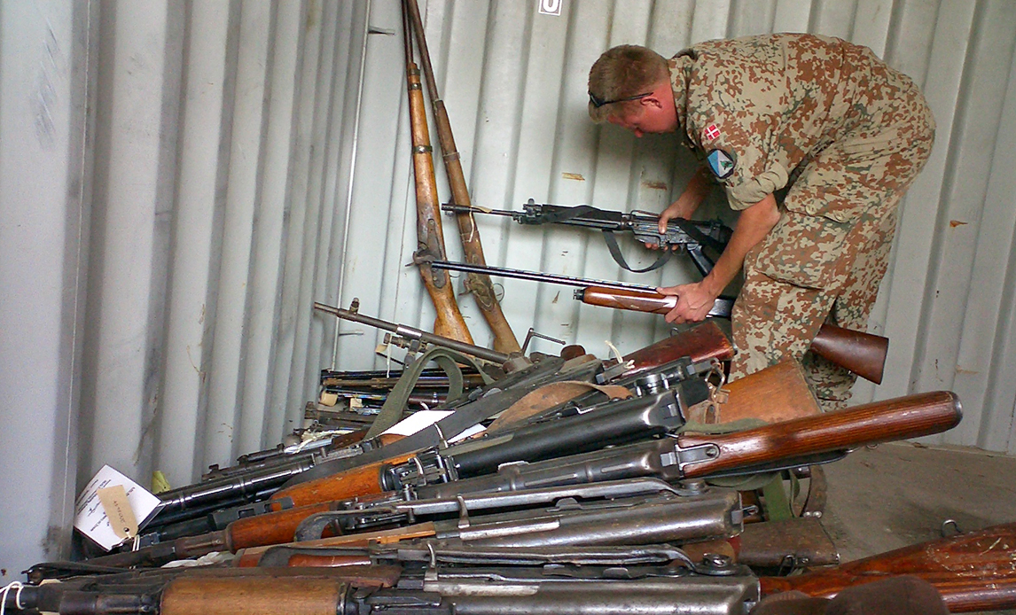 Soldat fra Opklaringsbataljonen sorterer konfiskerede våben.