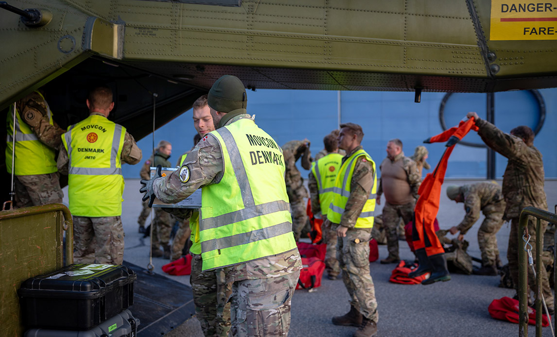Nationalt Støtteelement og Joint Movement and Transportation læsser cargo af en EH101-helikopter