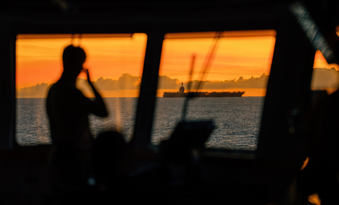 Amerikansk hangarskib i solopgang set fra broen på fregatten Niels Juel