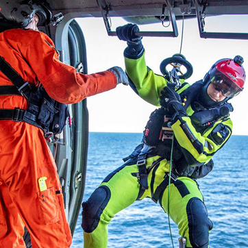 En redder hoistes fra en helikopter